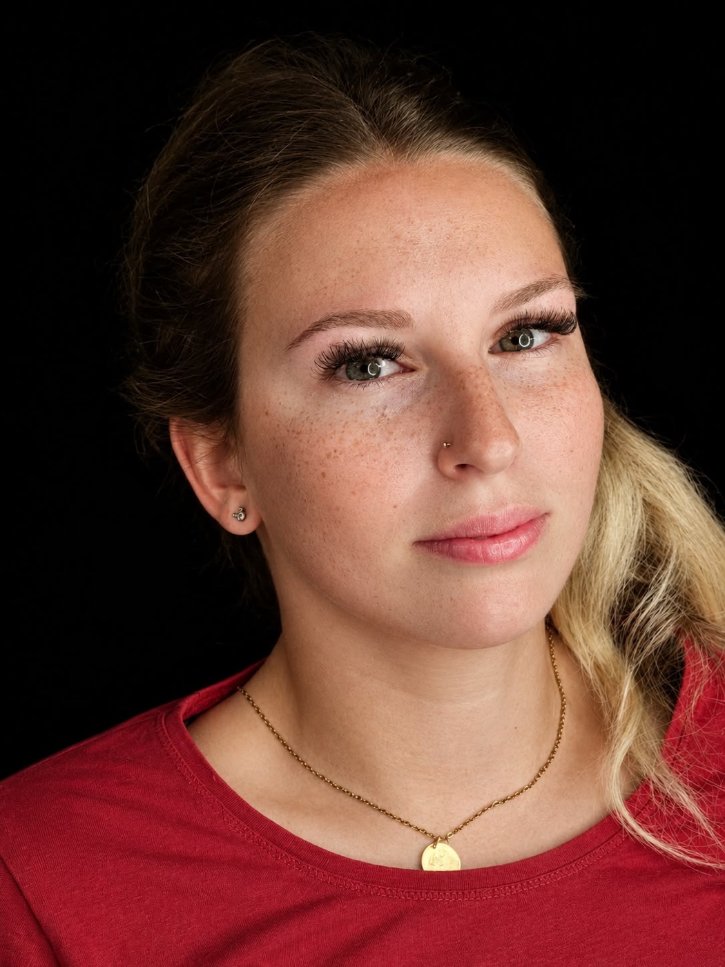 Gesicht mit Sommersprossen über Nase und Wangen